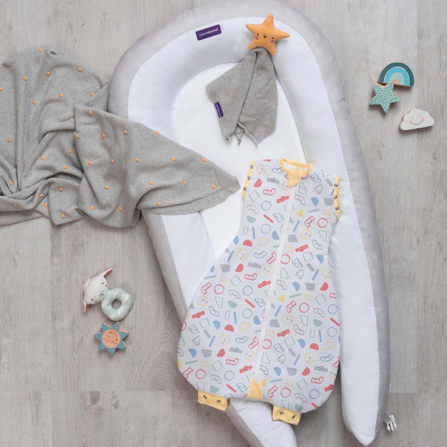 Baby sleeping bag with patterned design on a wooden surface with toys around