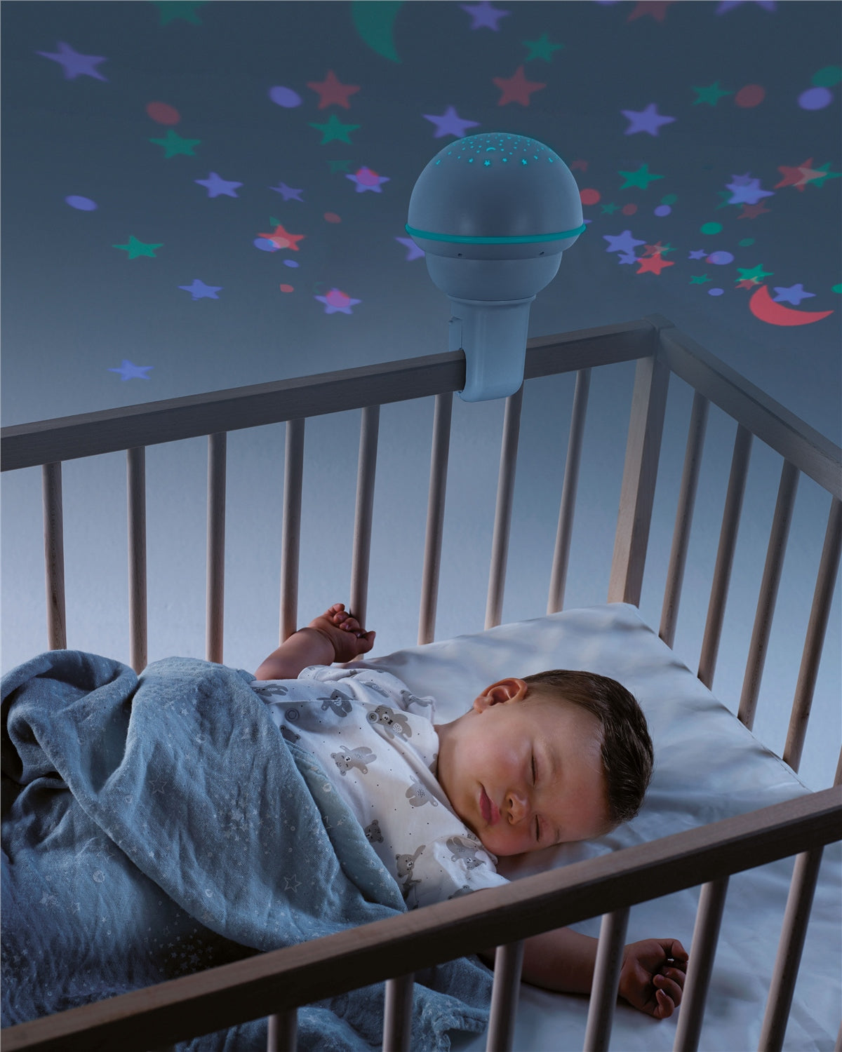 Child sleeping in a crib with a starry night light above
