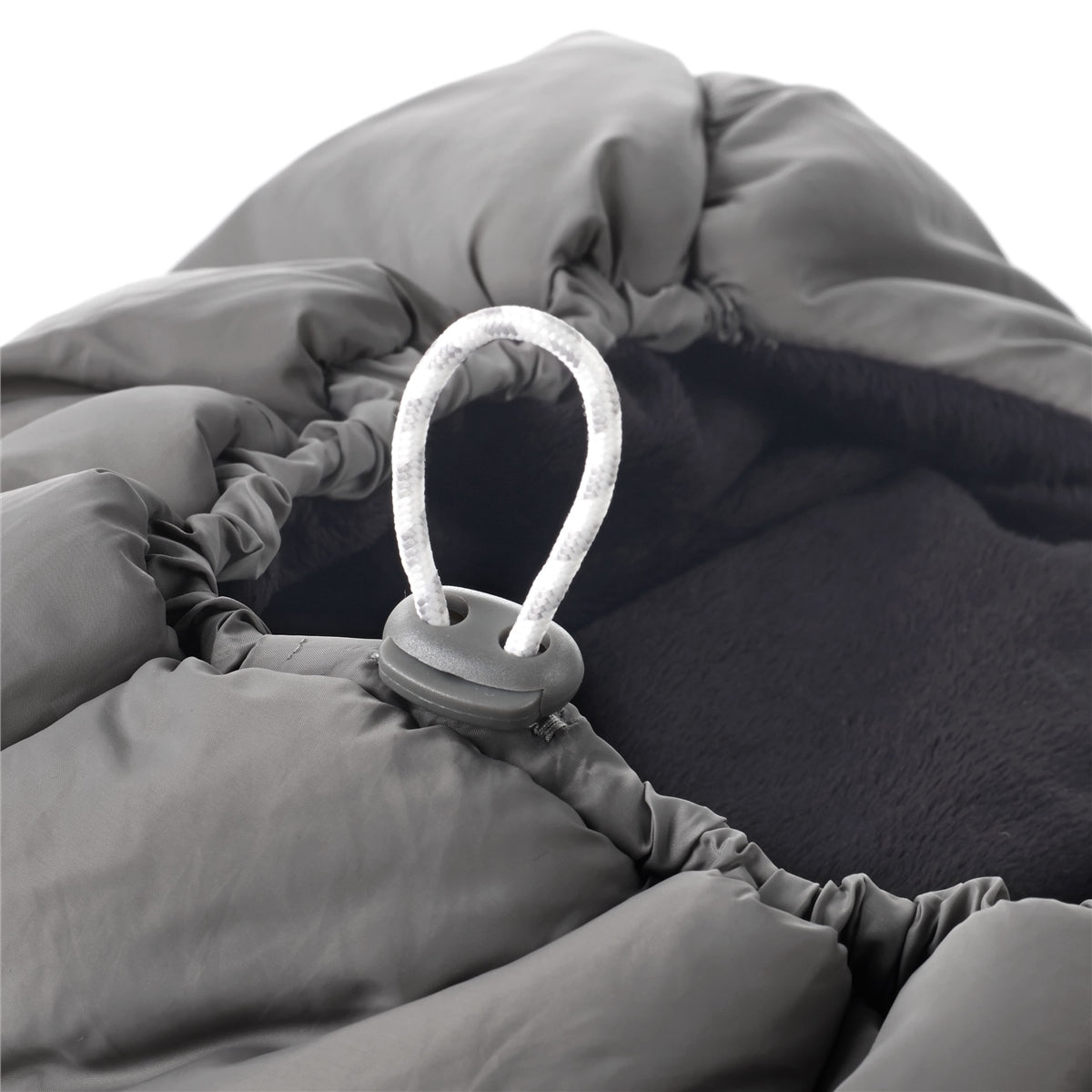 Gray sleeping bag with a small light attached on a white background