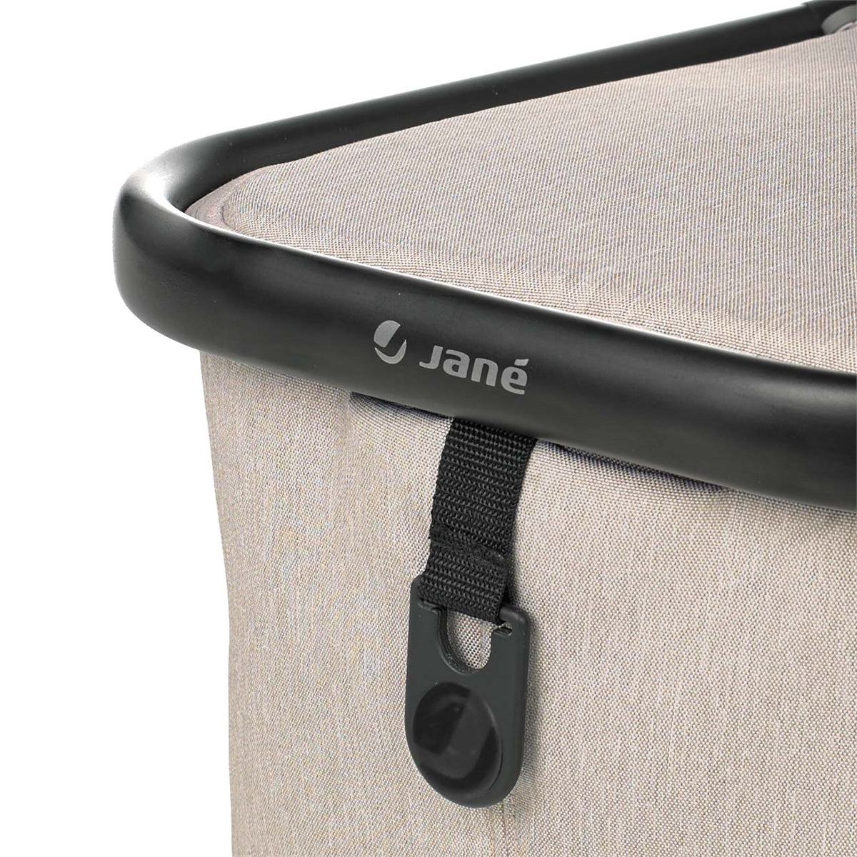 Close-up of a Jané product with a black handle and strap on a beige background