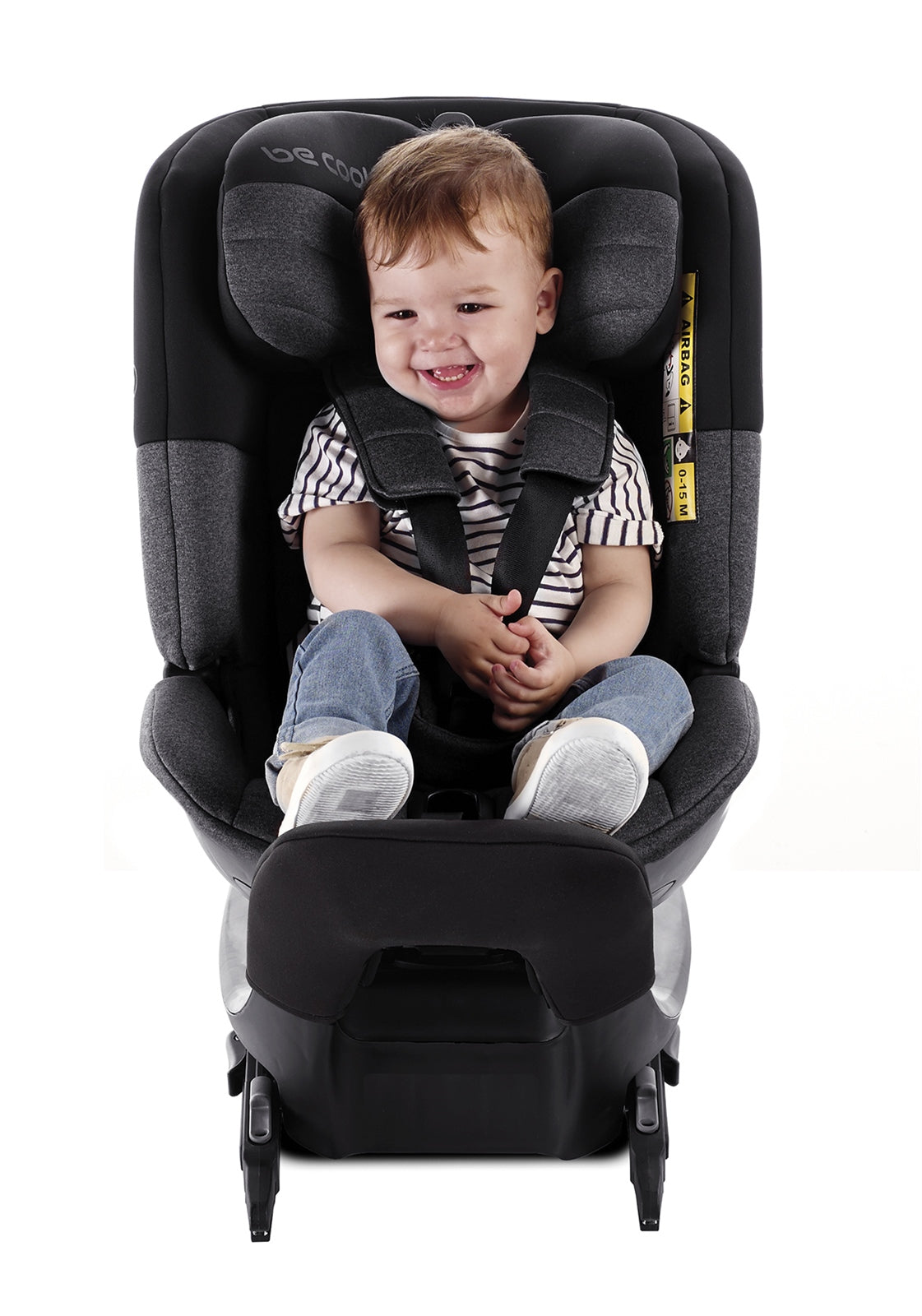 Child sitting in a black car seat with a white background