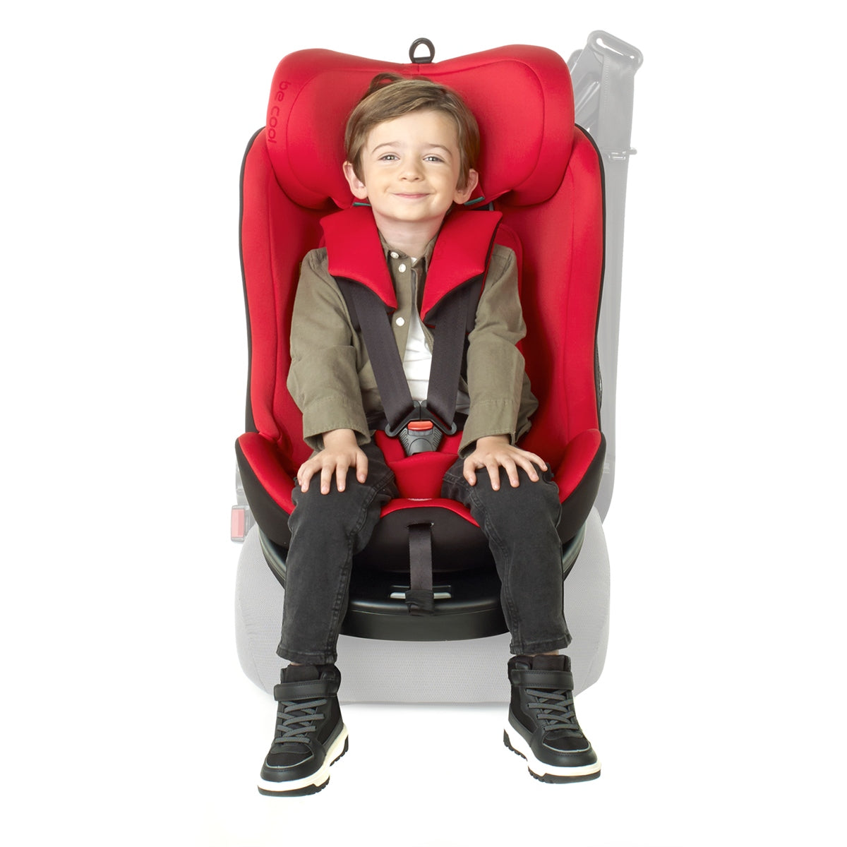Child sitting in a red car seat on a white background