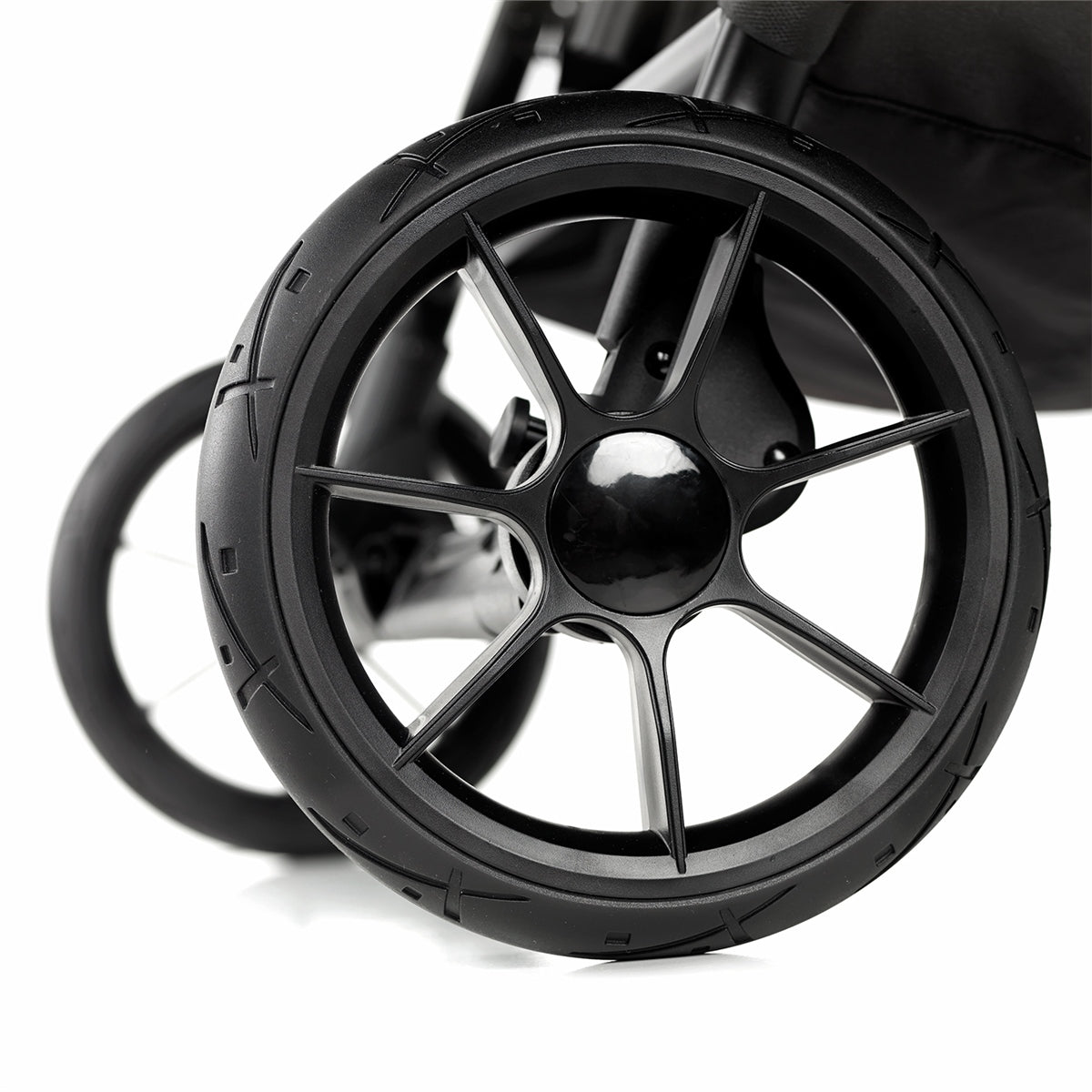 Close-up of a black stroller wheel on a white background