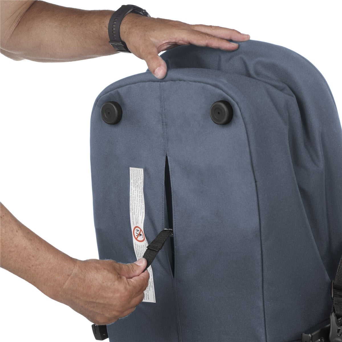 Person adjusting a blue carrycot with a white label on a white background