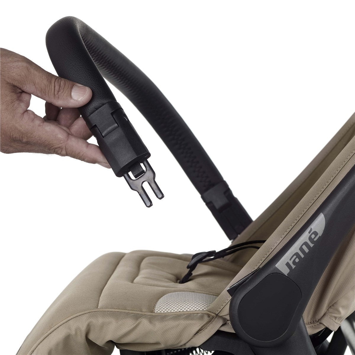 Close-up of a hand adjusting a stroller strap on a beige stroller with 'Jane' branding