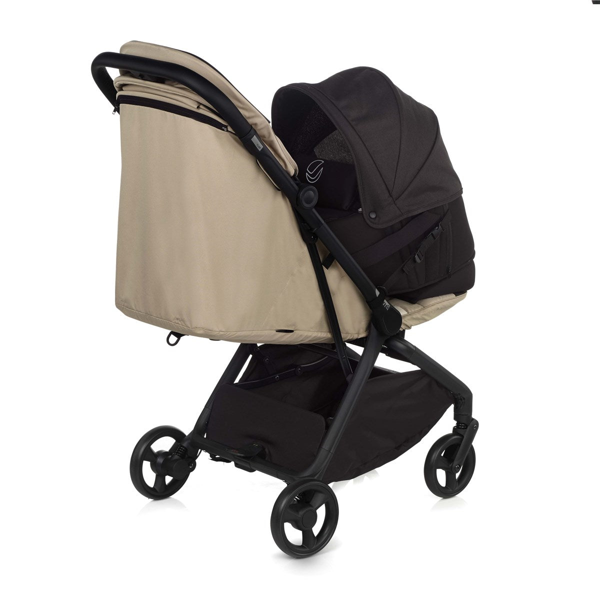 Baby stroller with beige canopy and black frame on a white background