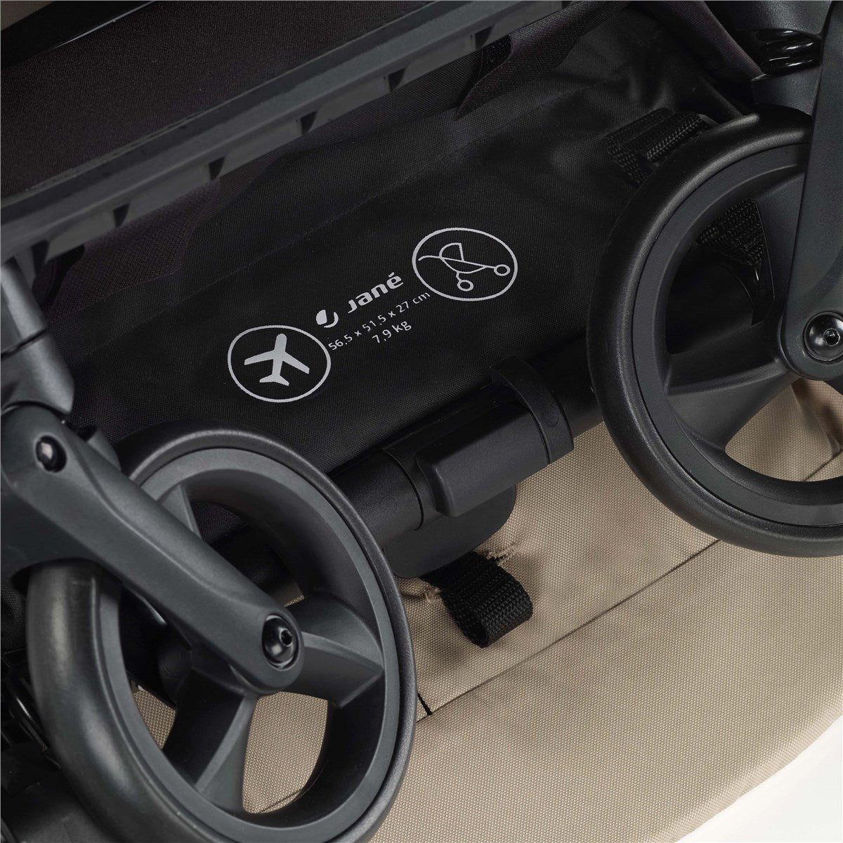 Close-up of a stroller wheel with visible branding on a beige background