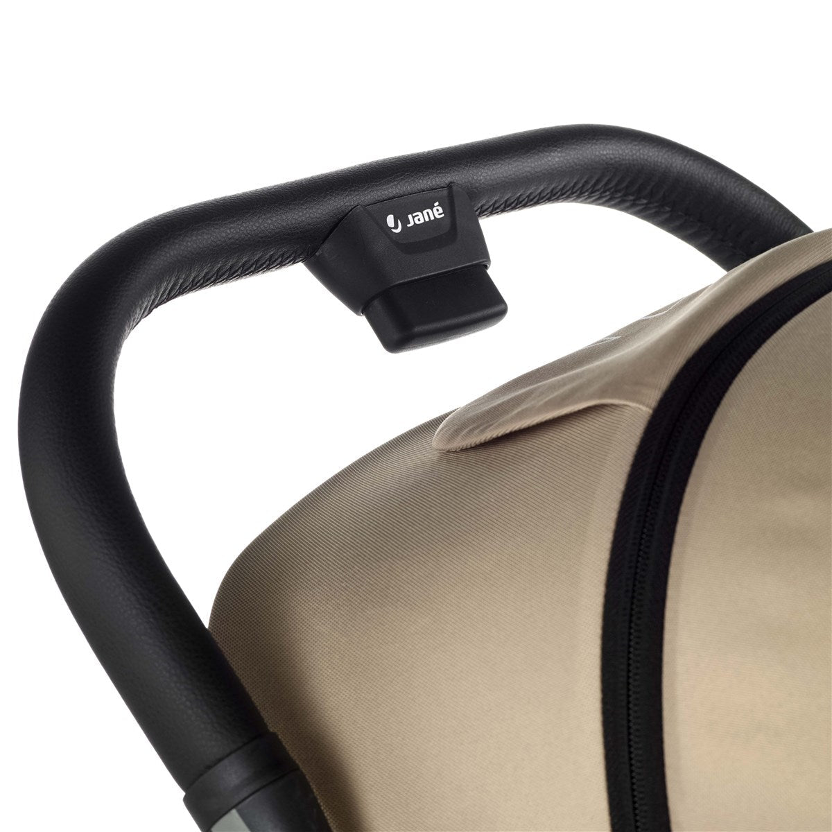 Close-up of a beige car seat with black handle and Jané logo.