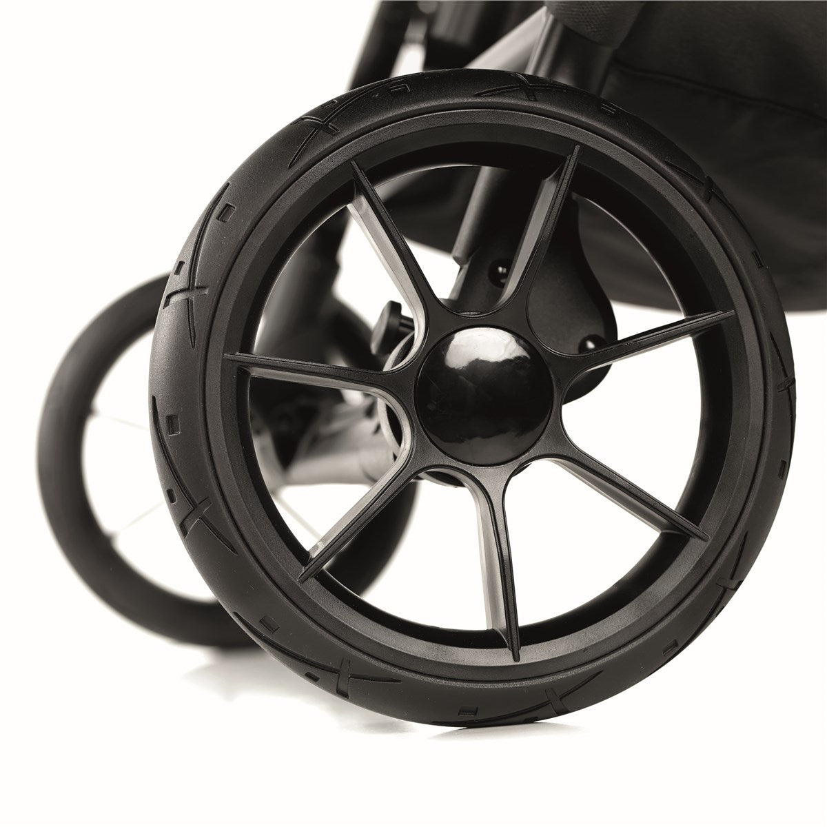 Close-up of a black stroller wheel on a white background