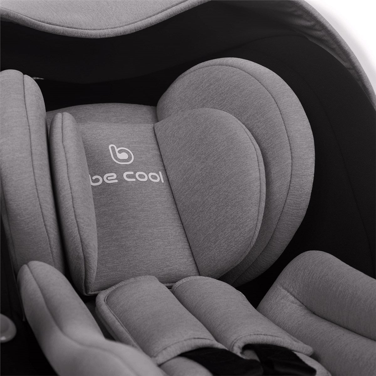 Gray car seat with 'be cool' logo on a dark background