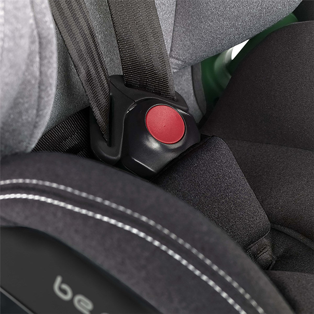 Close-up of a car seat with a red button and 'be' branding.