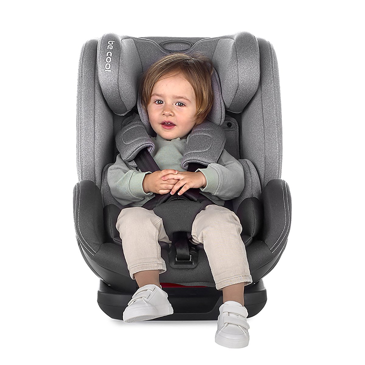 Child sitting in a gray car seat with a white background