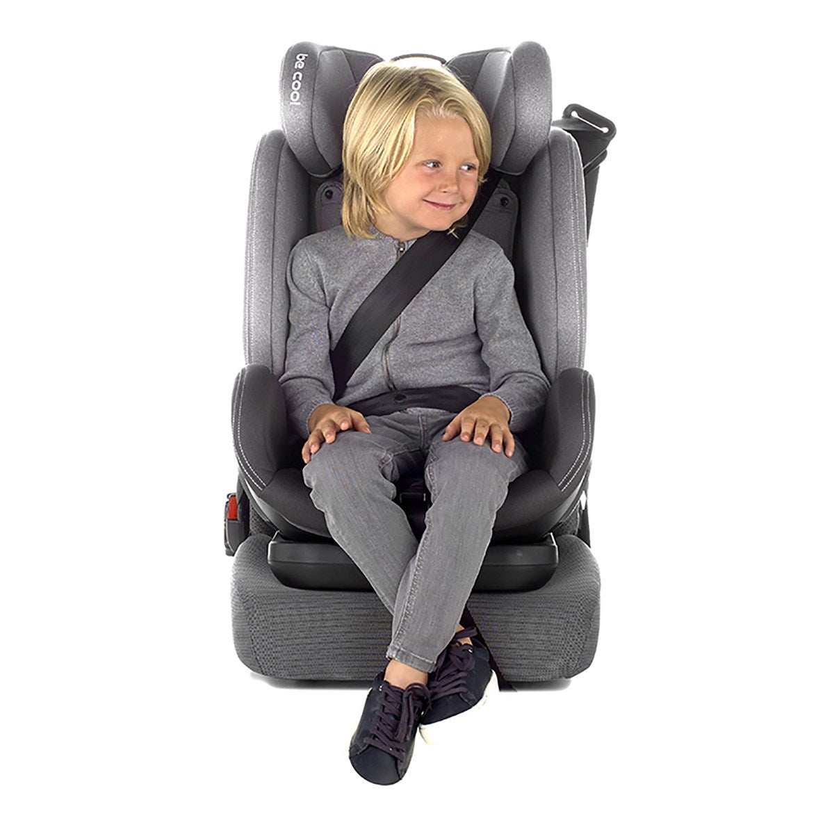 Child sitting in a gray car seat with a white background