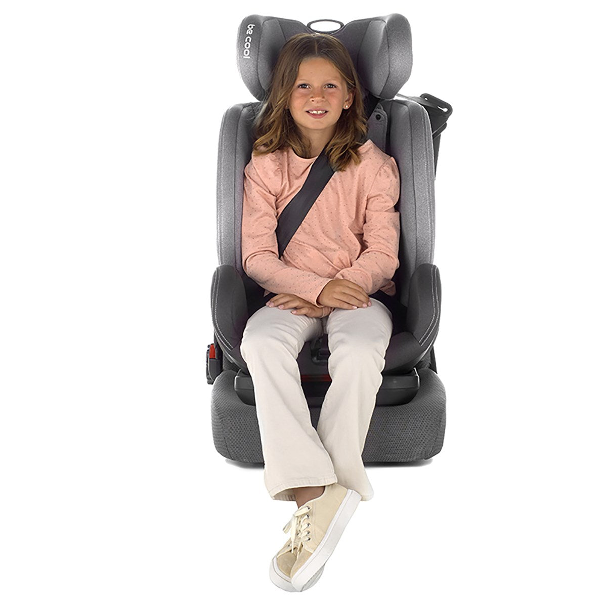 Child sitting in a gray car seat on a white background