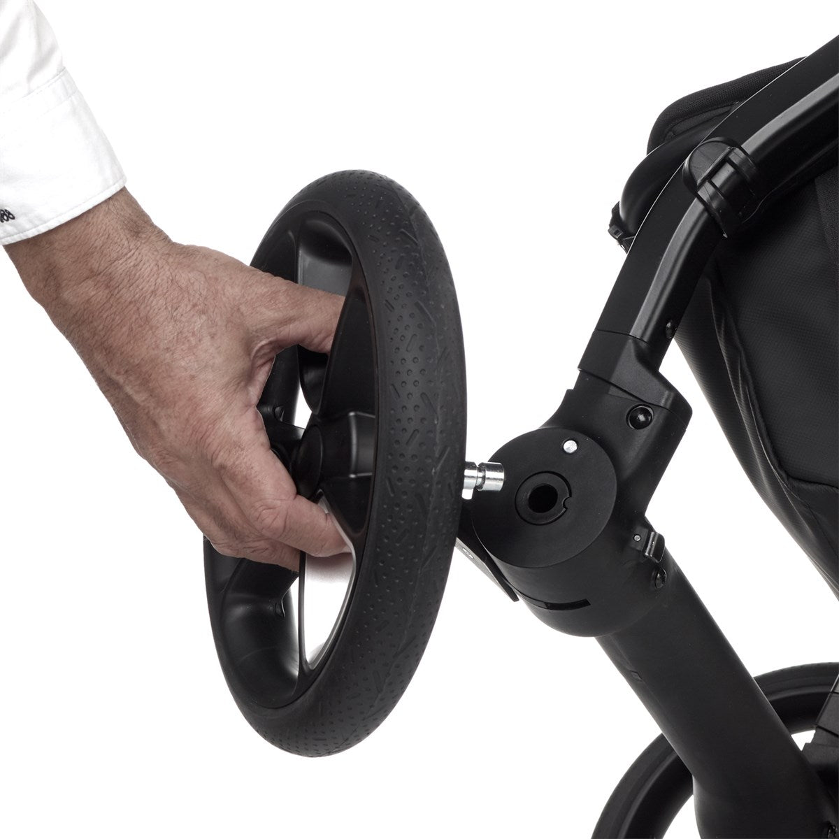 Hand adjusting a wheel on a black stroller against a white background