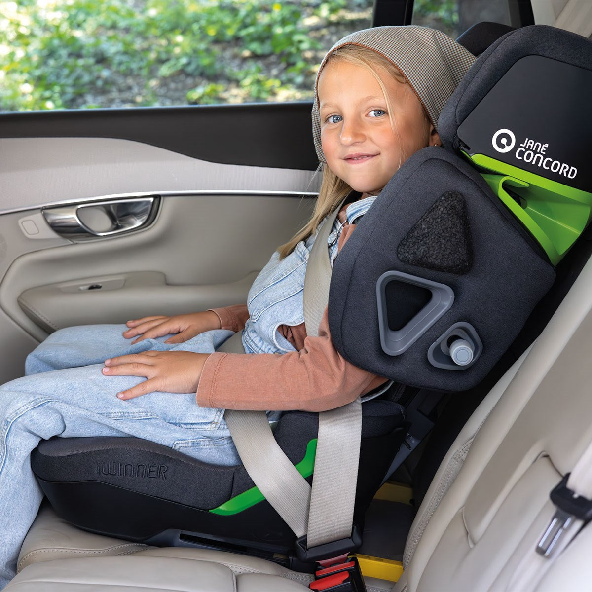 Child in a car seat with a visible brand logo inside a vehicle.