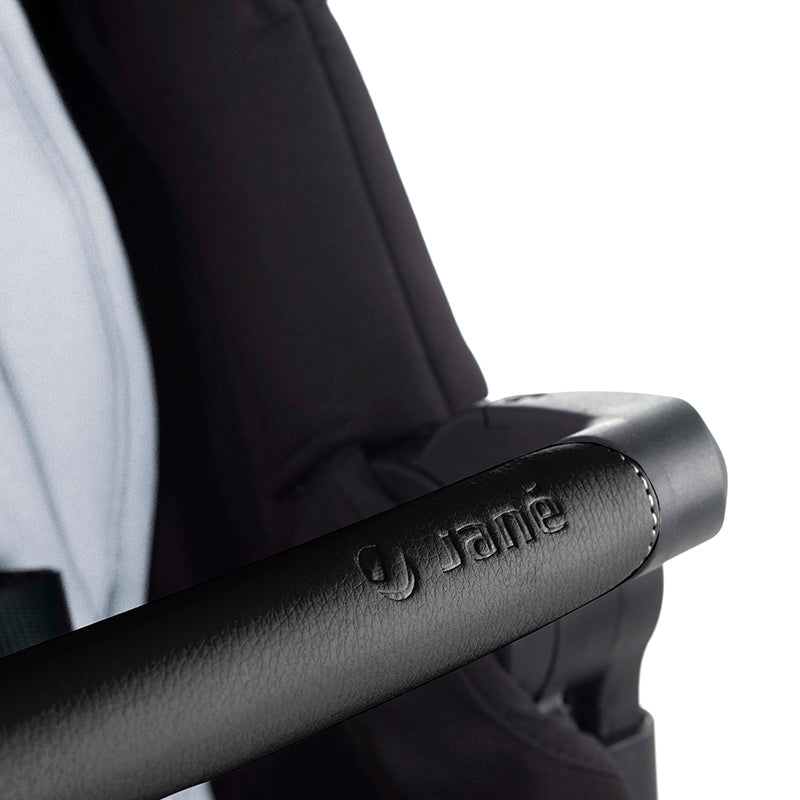 Close-up of a black stroller handle with 'Jane' branding on a white background