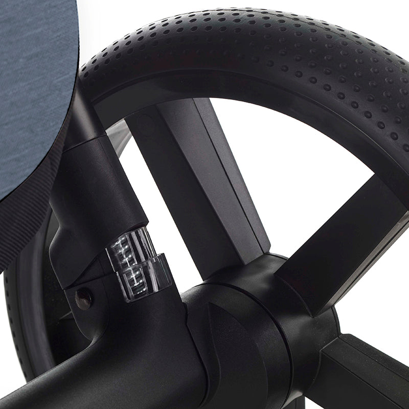 Close-up of a black stroller  wheel with a detailed hub on a white background