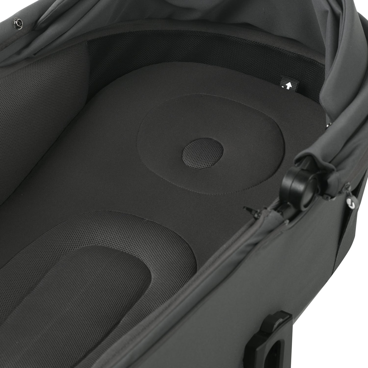 Close-up of a black stroller seat with circular patterns