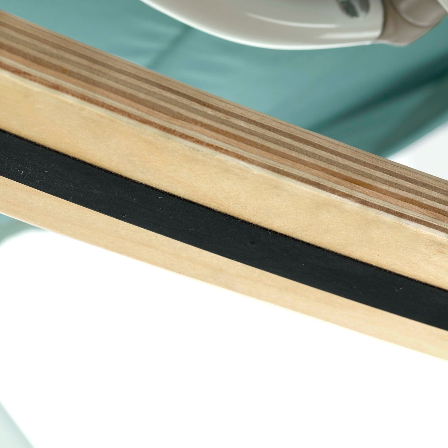 Close-up of a wooden strip with black rubber band on a reflective surface