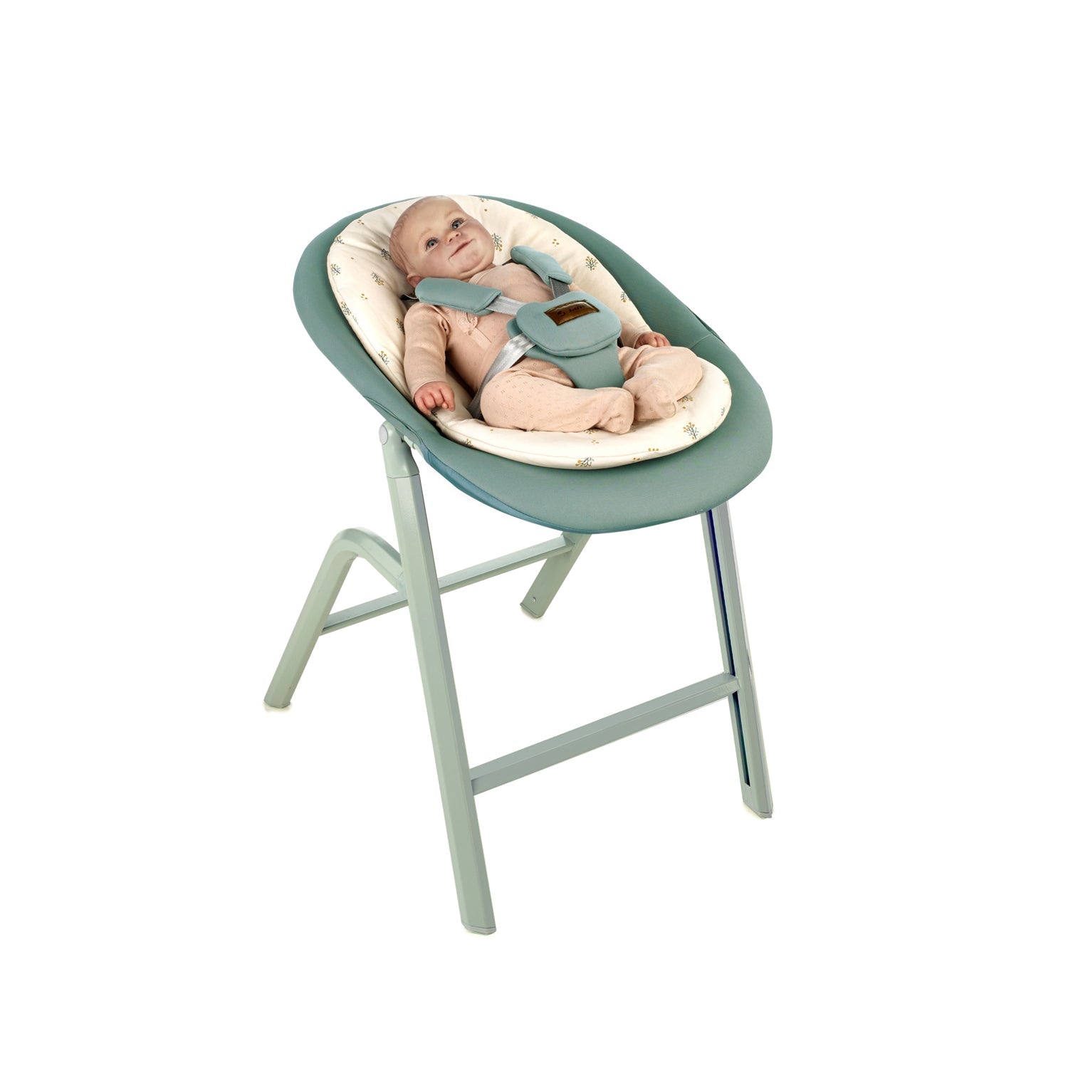 Baby in a green and beige baby seat on a white background