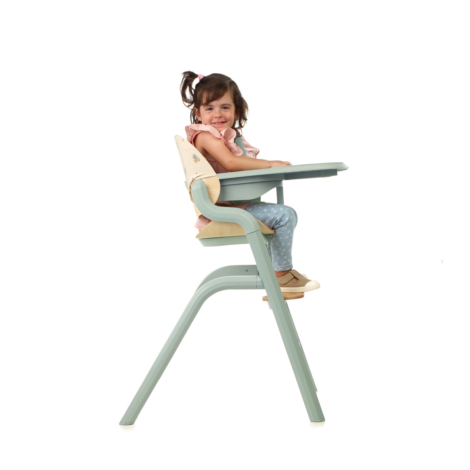 Child sitting in a modern high chair with a white background