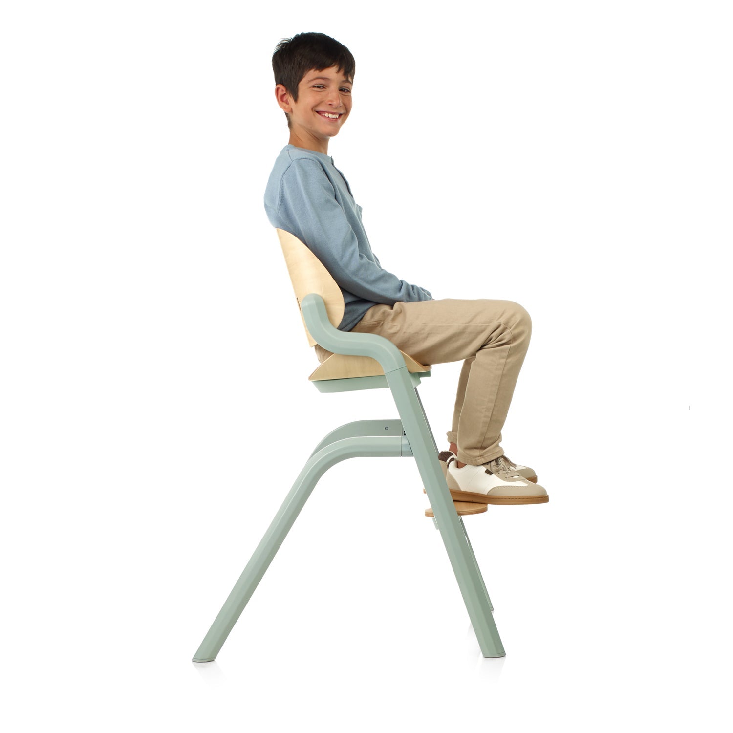 Child sitting on a modern chair with a white background