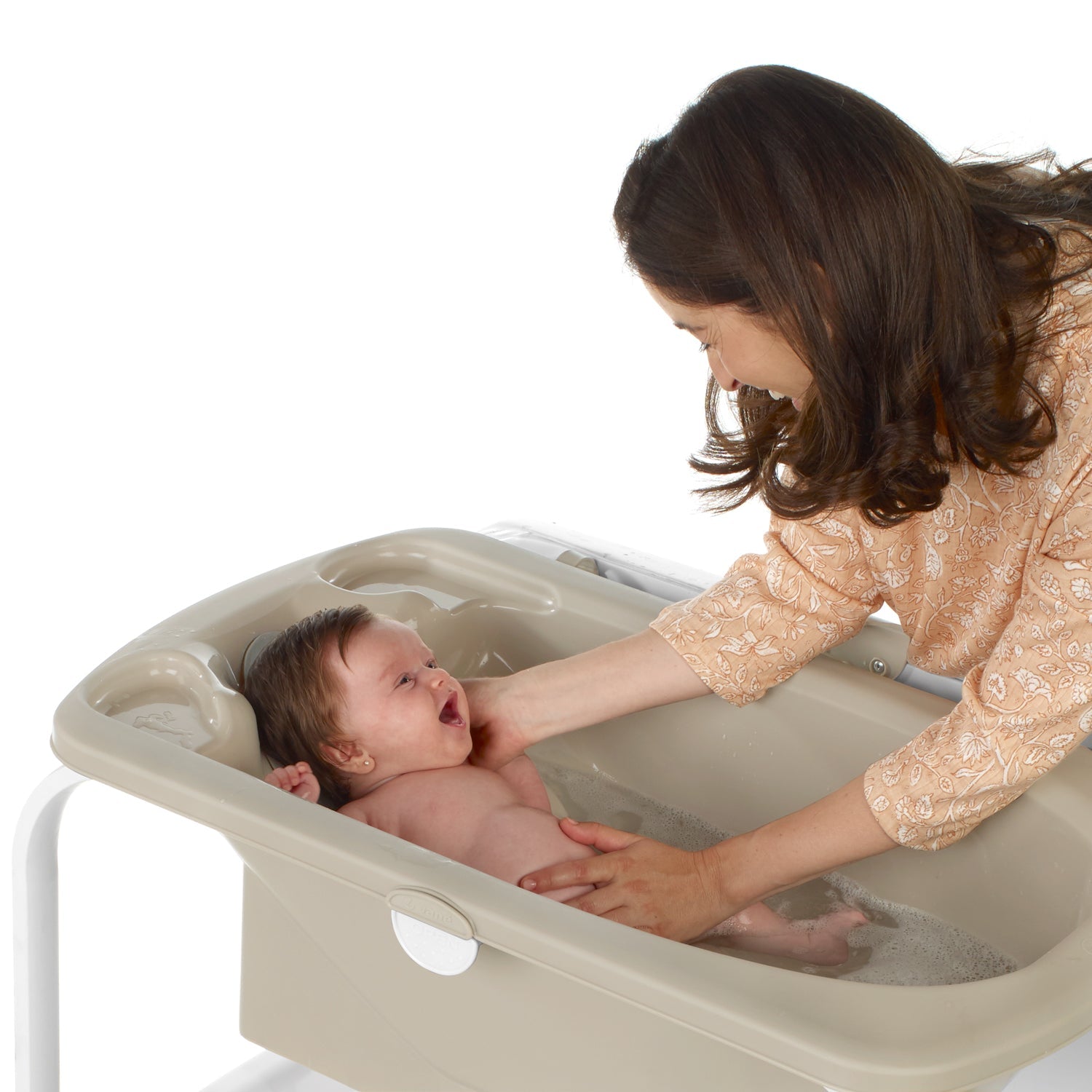 Woman bathing a baby in a portable bathtub on a white background