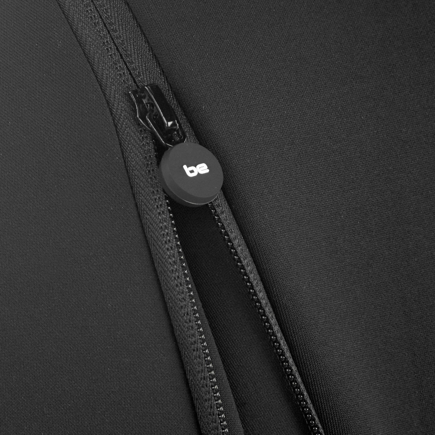 Close-up of a black zipper with a brand logo on a black background
