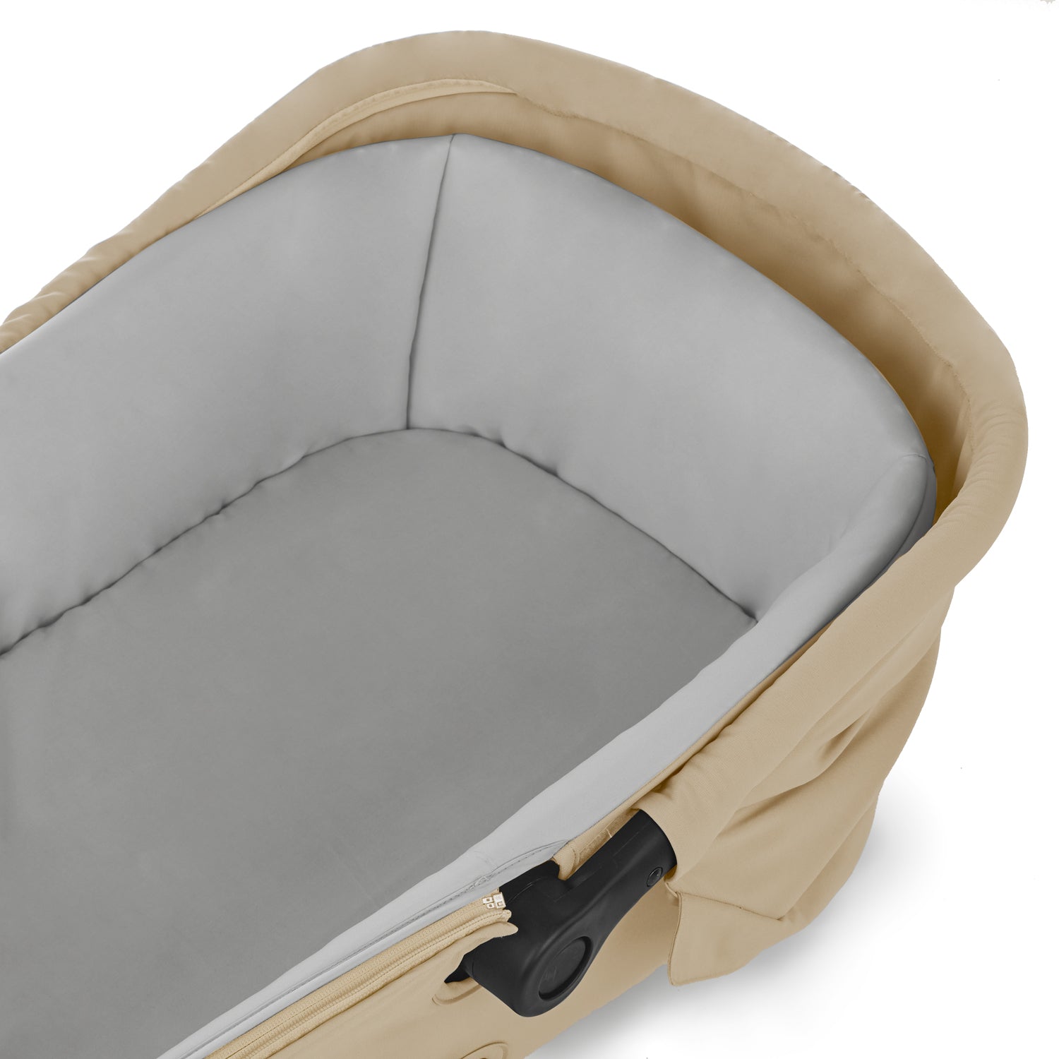 Close-up of a beige and gray baby carrier with a black clip on a white background