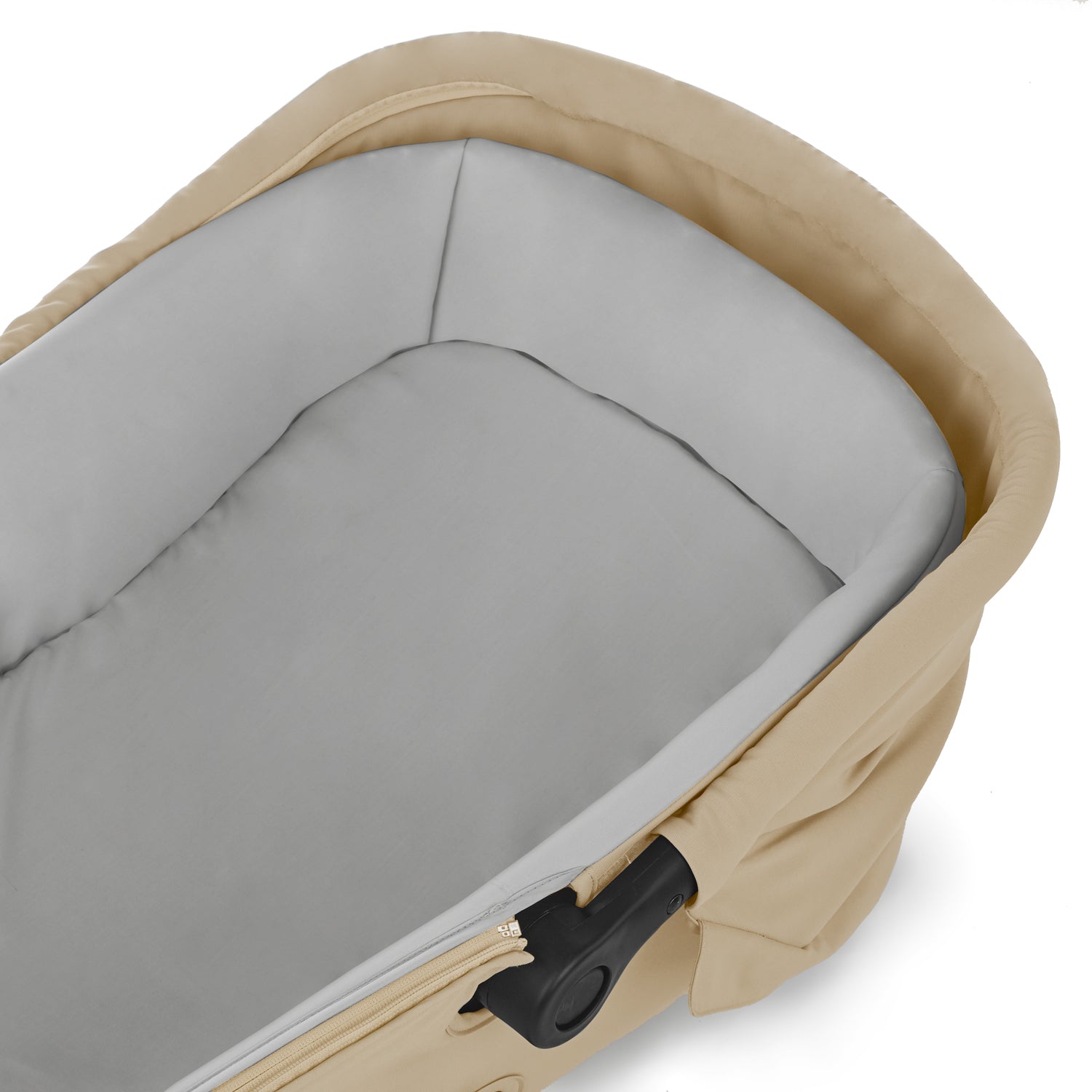 Close-up of a beige and gray baby carrier with a zipper.