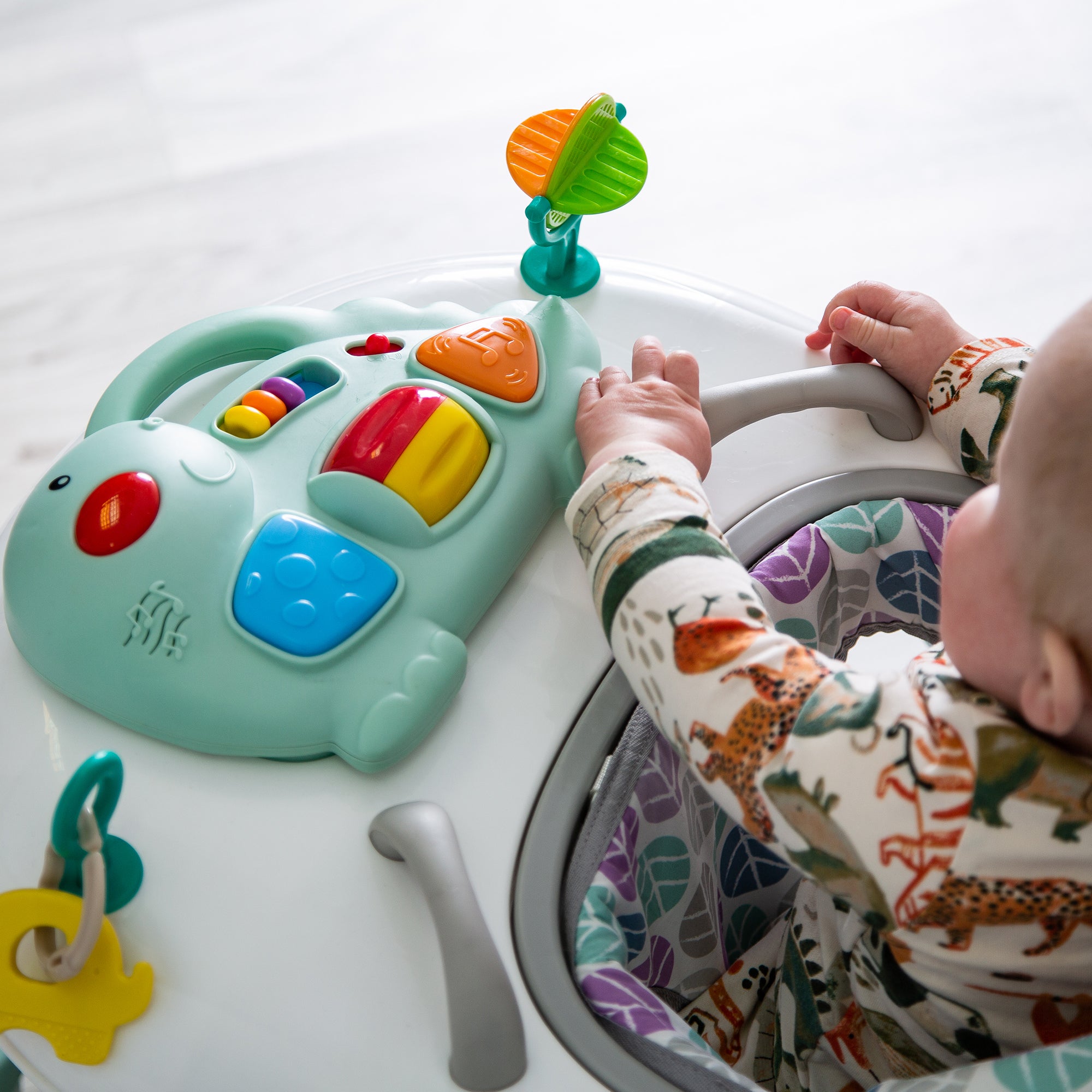Child playing with a colorful toy walker on a light background