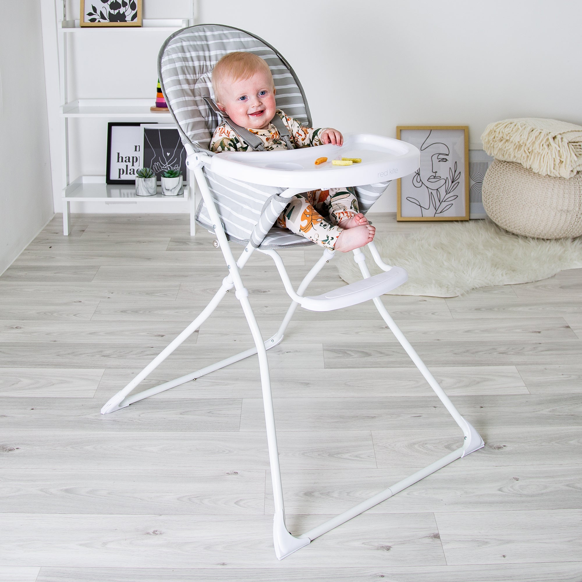 Baby sitting in a modern high chair in a minimalistic room.