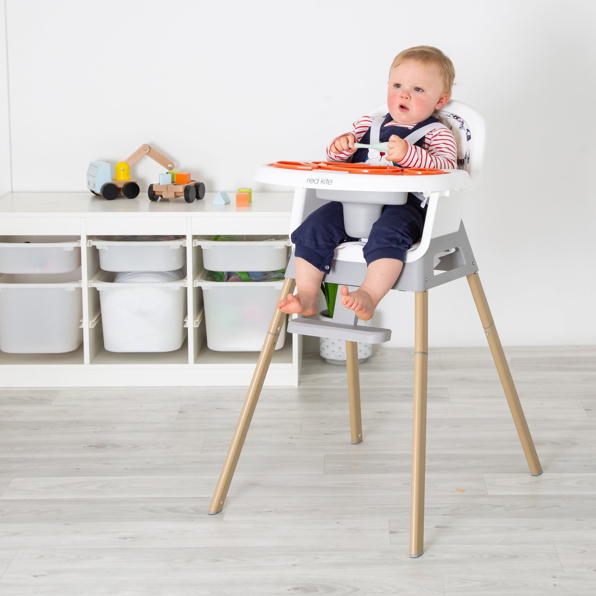 Child in a high chair with a white background