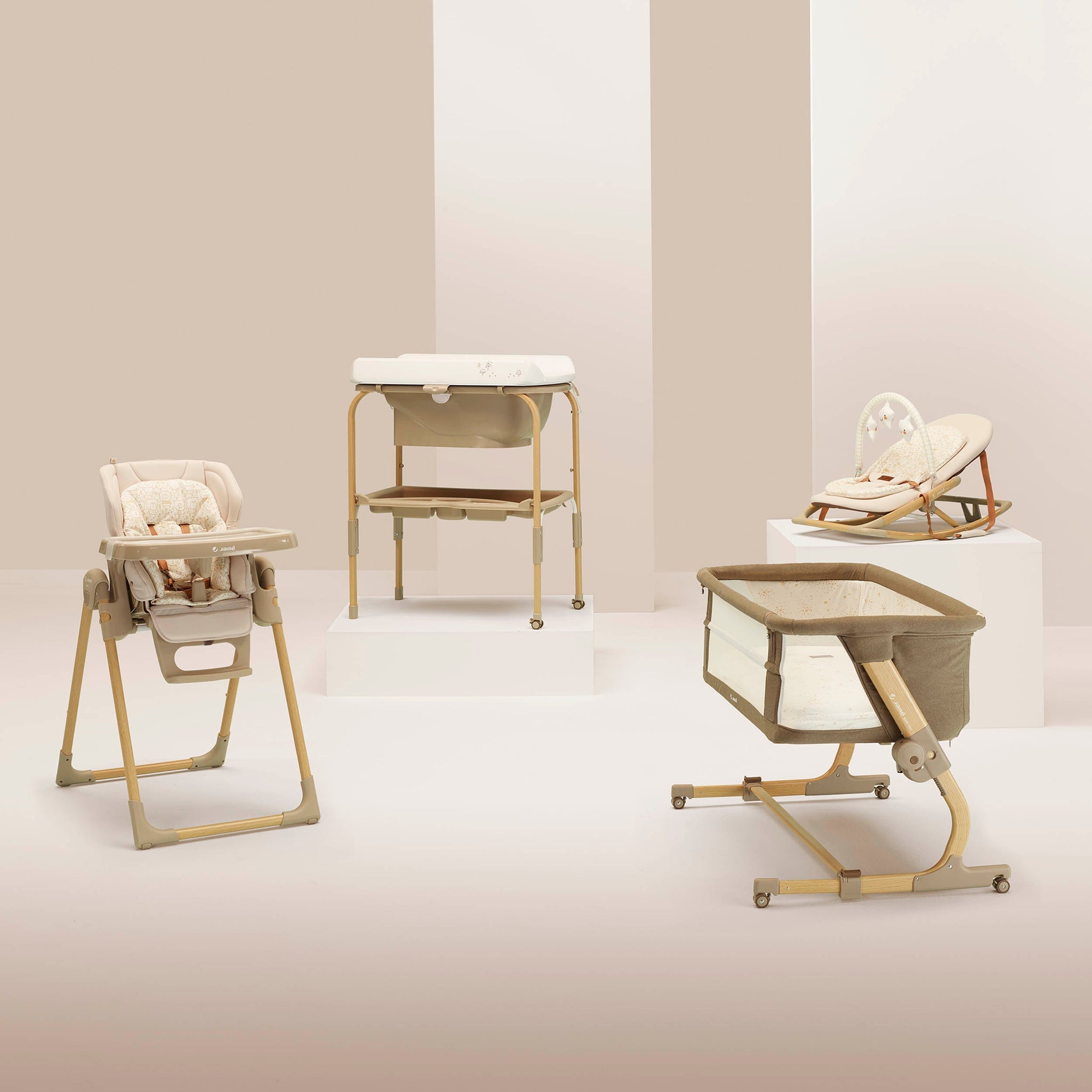 Collection of baby furniture including a high chair, bassinet, and rocking chair on a neutral background.