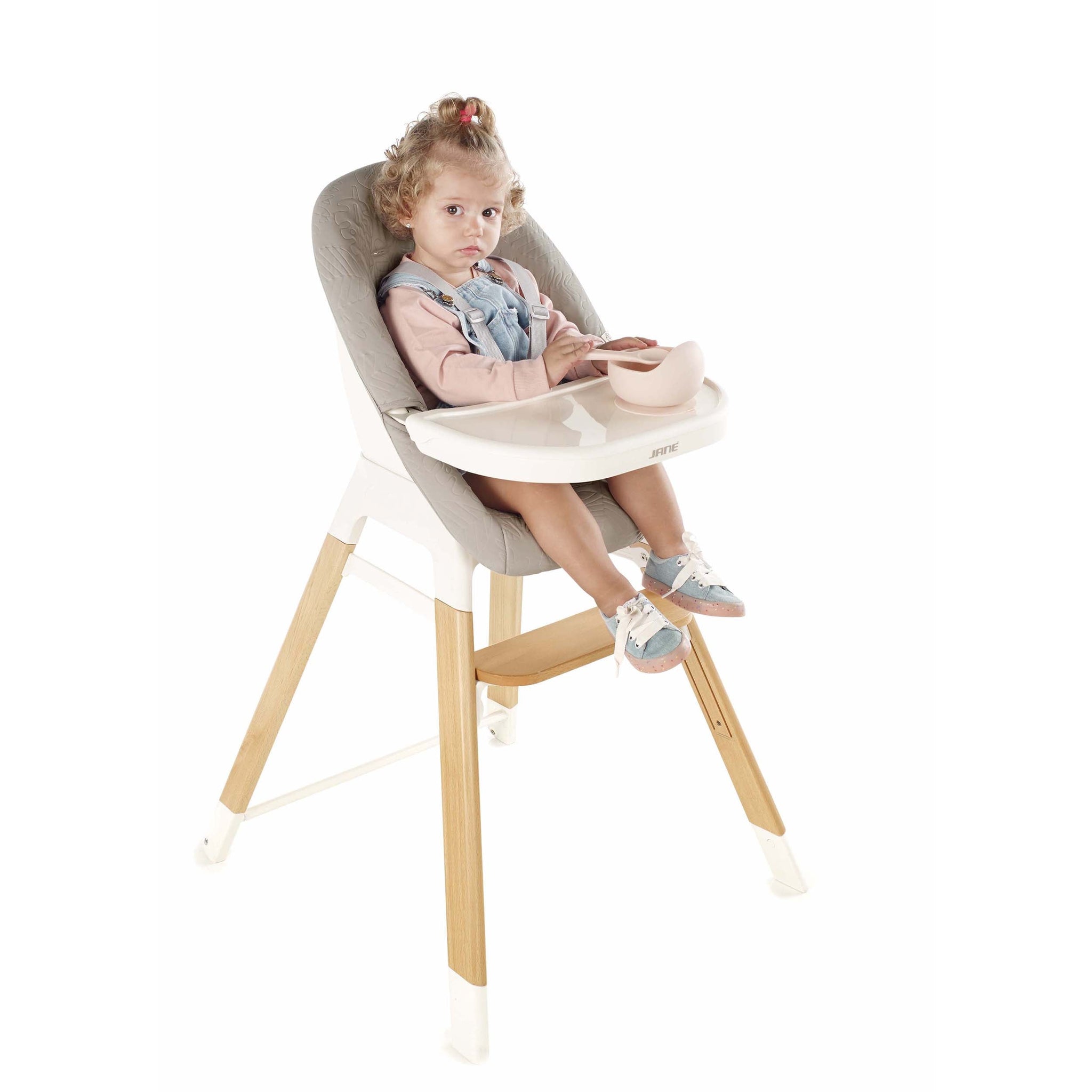 Child sitting in a high chair with a white background