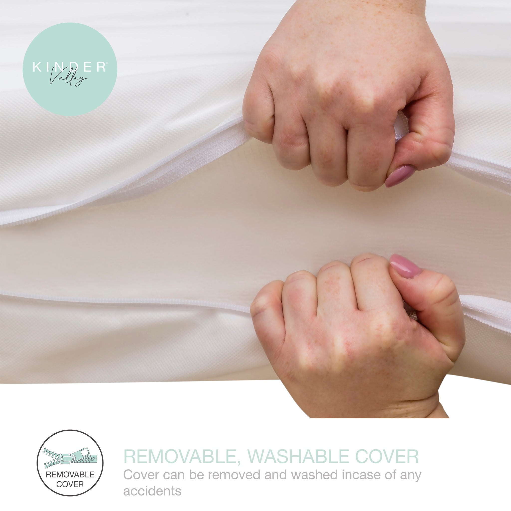 Two hands holding a white mattress cover with 'Kinder Valley' branding.