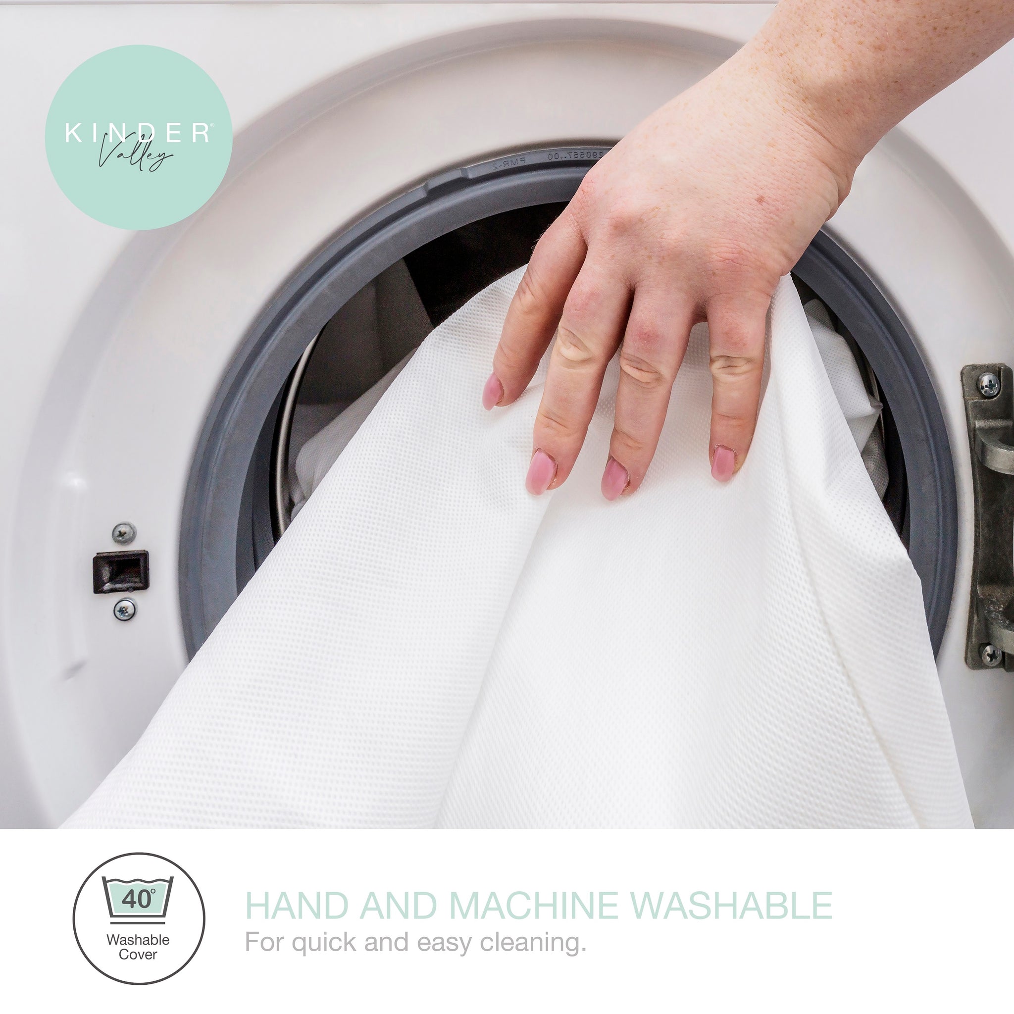 Hand placing a white fabric into a washing machine with 'Kinder Valley' branding.