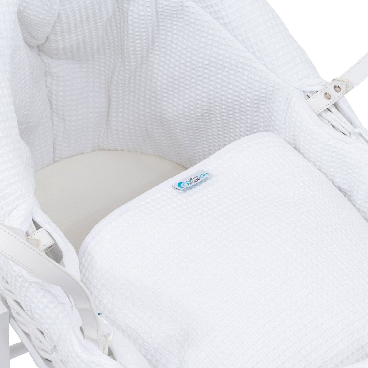 White wicker chair with a white cushion and a visible brand logo.